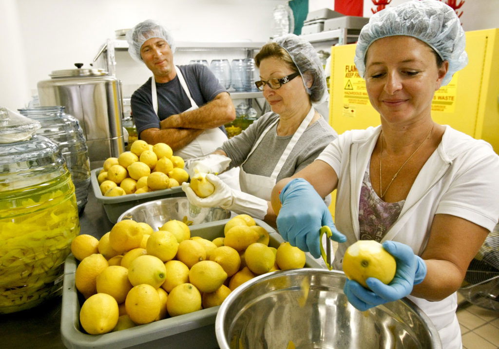 L to R James Carling watches as his mother in law Rossana (CQ) Zaretti and wife Manuela ZarettiCarling (CQ) peel about 3000 lemons to make limoncello following a recipe from an Italian grandmother, Maria Antonia MorettiBiancucci (CQ) at the Ventura Limoncello Company in Ventura on September 9, 2010. Rossana does not like James to peel the lemons so he performs other tasks.  (Photo by Anne Cusack/Los Angeles Times via Getty Images)